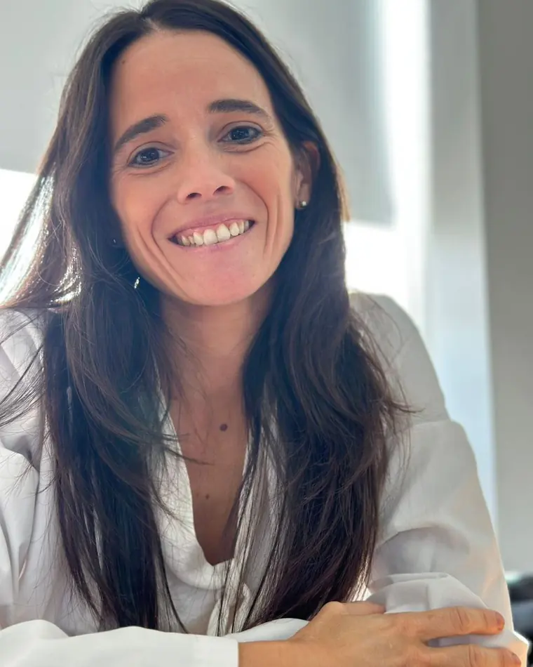 La Dra. María Guadalupe Cuevillas, de brazos cruzados, en su consultorio